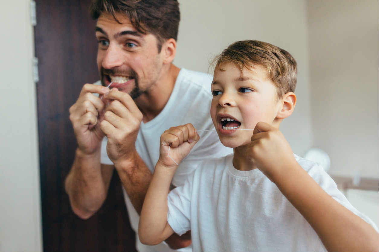 child flossing with father