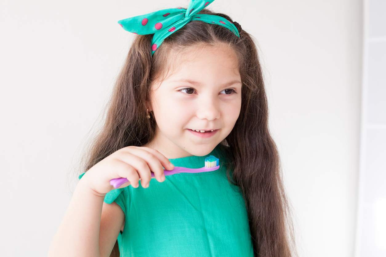 little girl brushing her teeth